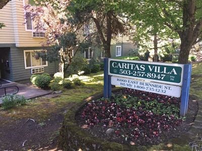 a sign for the caritas villa subdivision in front of a house